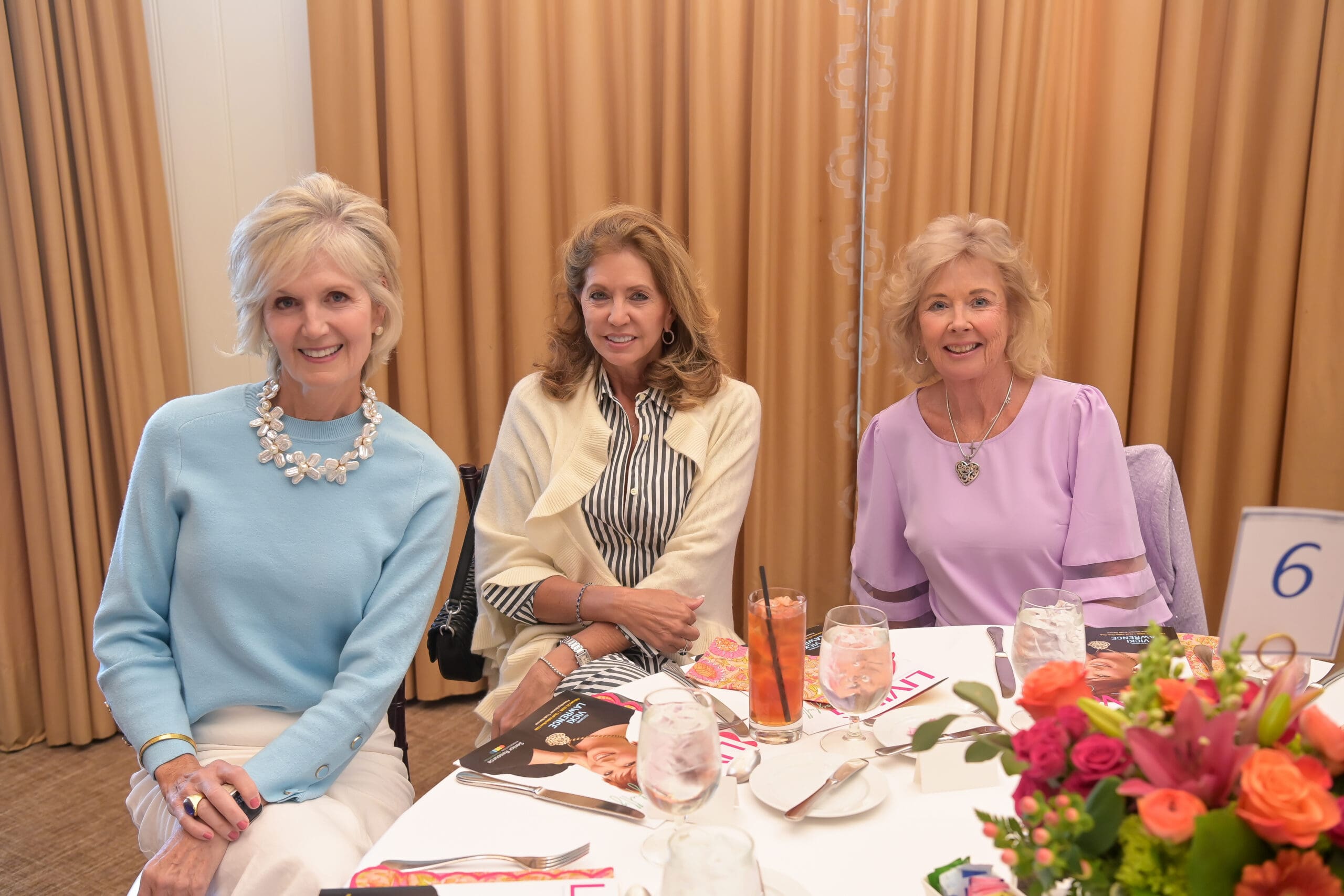 Attendees smiling for a photo at the luncheon.