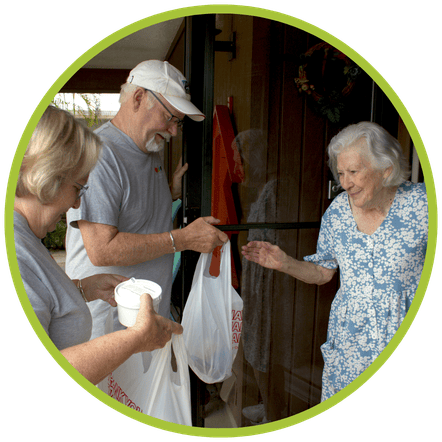 Meals on Wheels volunteers delivering a meal to a senior.